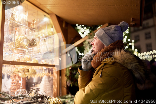 Image of happy man looking at christmas market shop window