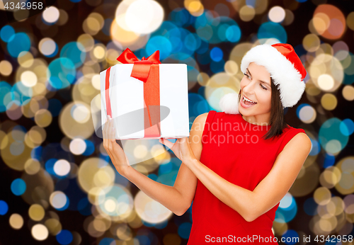Image of smiling woman in santa hat with christmas gift