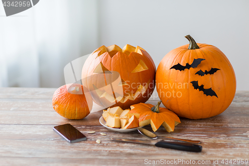 Image of halloween jack-o-lantern, pumpkins and smartphone