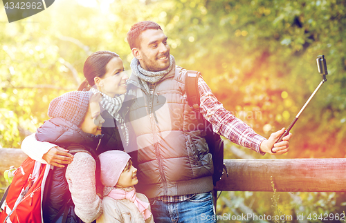 Image of happy family with smartphone selfie stick in woods