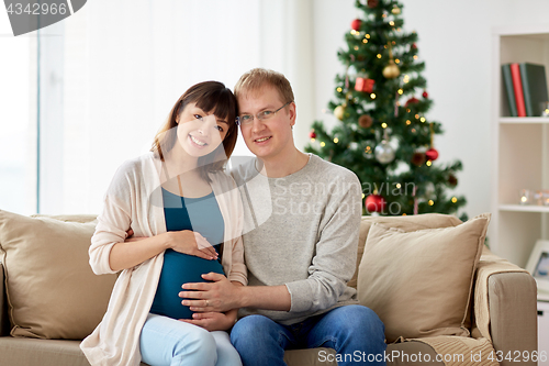 Image of pregnant wife with husband at home at christmas