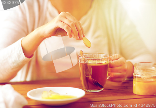 Image of close up of ill woman drinking tea with ginger