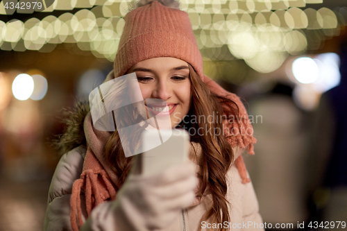 Image of happy woman with smartphone at christmas