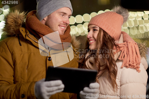 Image of happy couple with tablet pc at christmas market
