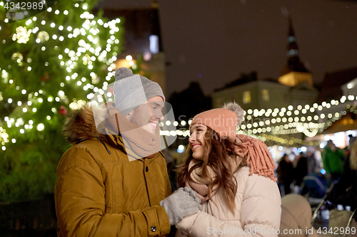 Image of happy couple holding hands at christmas market