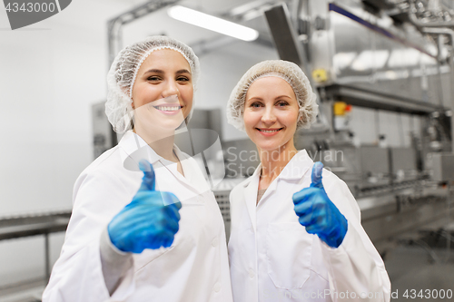 Image of happy women technologists at ice cream factory