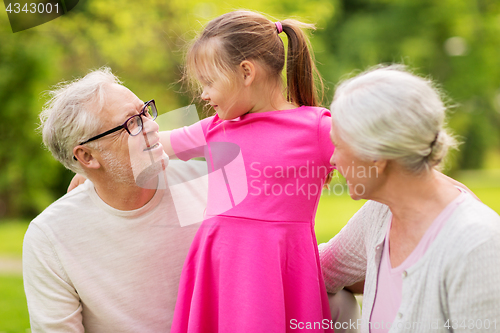 Image of senior grandparents and granddaughter at park