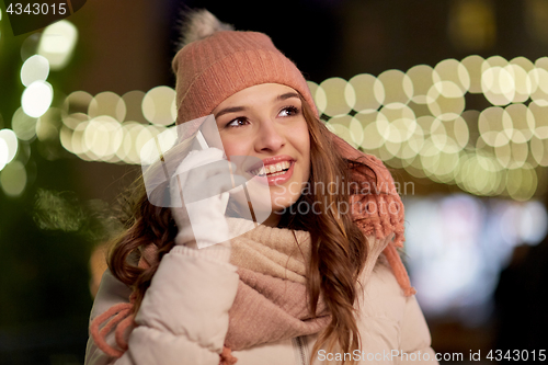 Image of happy woman calling on smartphone at christmas