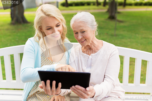 Image of daughter with tablet pc and senior mother at park