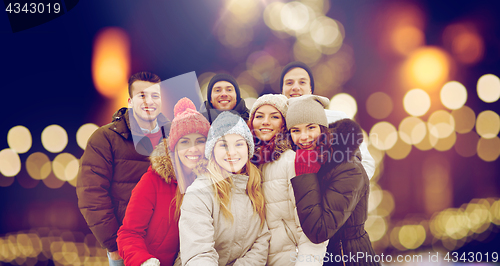 Image of happy friends taking selfie outdoors at christmas