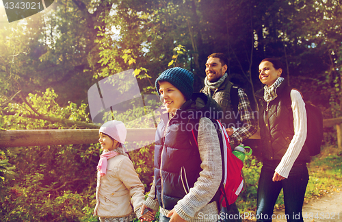 Image of happy family with backpacks hiking in woods