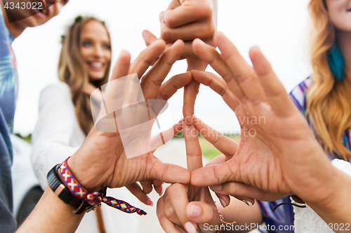 Image of hands of hippie friends showing peace sign