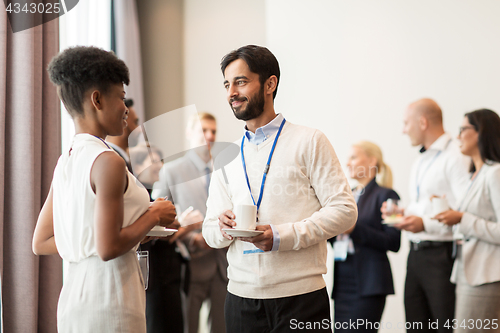 Image of business people with conference badges and coffee