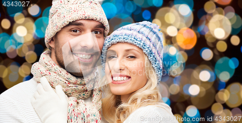 Image of happy couple in hats over lights background