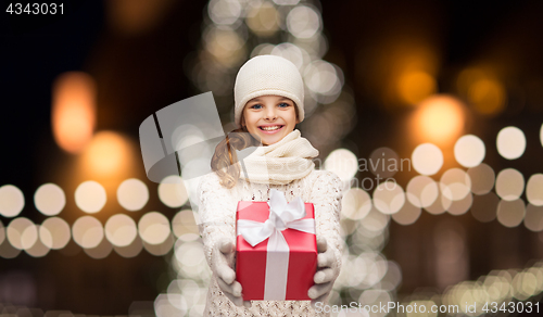 Image of happy girl in winter clothes with gift box
