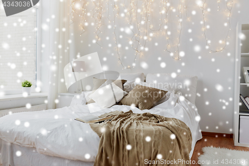 Image of bedroom with bed and christmas garland at home