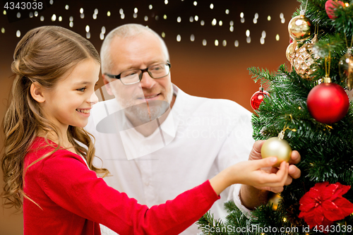 Image of happy family decorating christmas tree