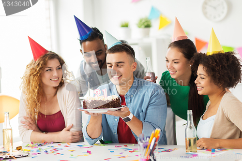 Image of man with birthday cake and team at office party