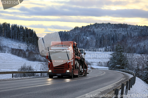 Image of Car Carrier on Winter Road at Dusk