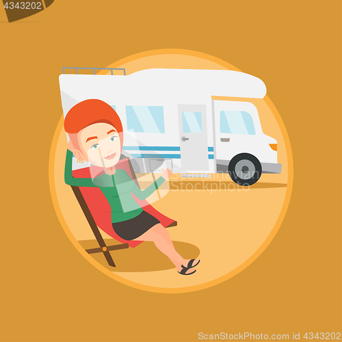 Image of Woman sitting in chair in front of camper van.