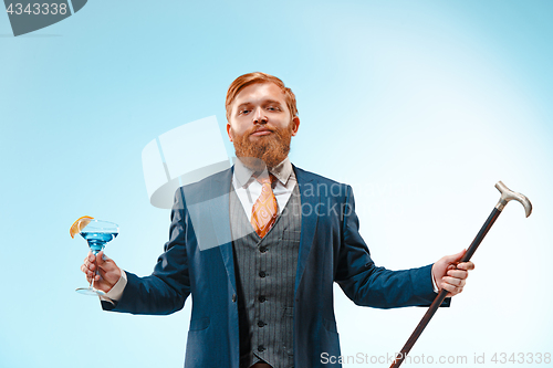 Image of The barded man in a suit holding cane.