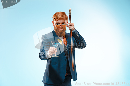 Image of The barded man in a suit holding cane.