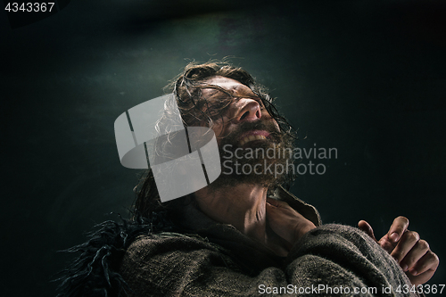 Image of Portrait of a brutal bald-headed viking in a battle mail posing against a black background.