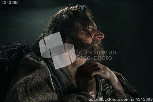 Image of Portrait of a brutal bald-headed viking in a battle mail posing against a black background.