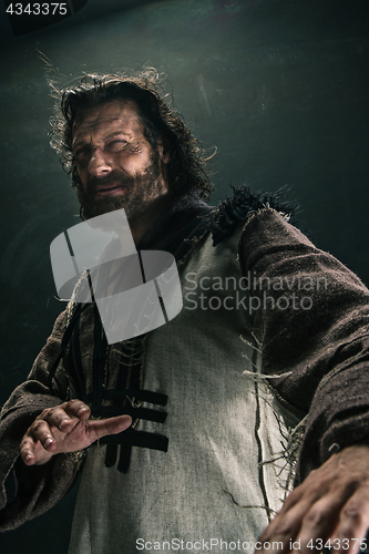 Image of Portrait of a brutal bald-headed viking in a battle mail posing against a black background.