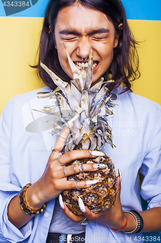 Image of lifestyle people concept. young pretty smiling indian girl with pineapple, asian summer fruits 