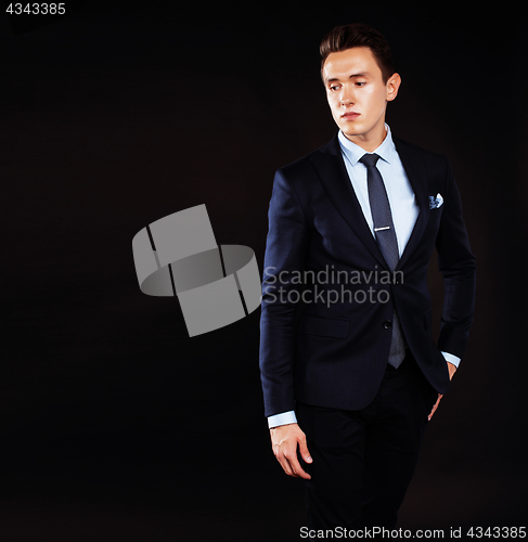 Image of young pretty business man standing on black background, modern h