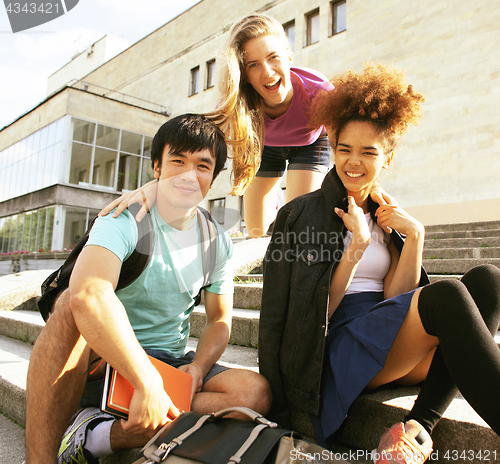 Image of cute group of teenages at the building of university with books 