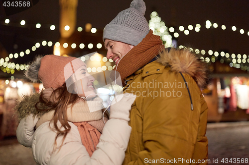 Image of happy couple holding hands at christmas tree