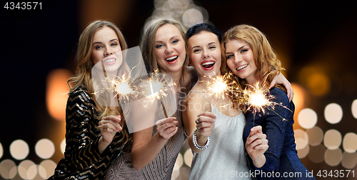 Image of happy young women with sparklers at new year night