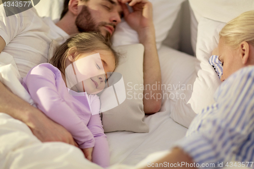 Image of happy family sleeping in bed at home