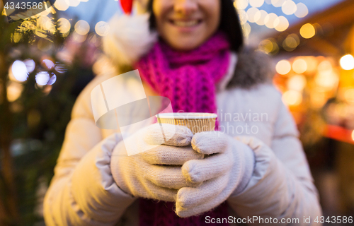 Image of woman with cup of hot drink at christmas market