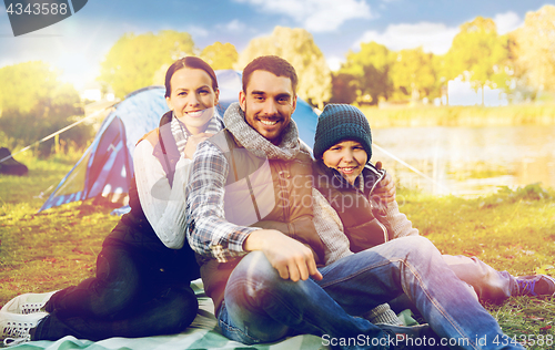 Image of happy family with tent at camp site