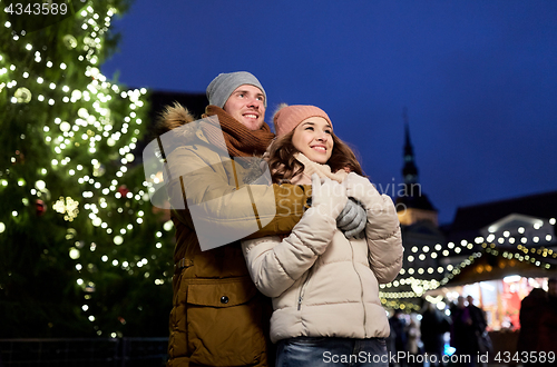 Image of happy couple hugging at christmas tree