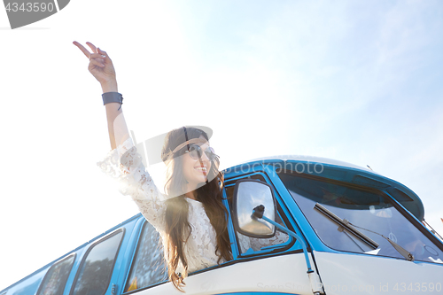 Image of happy hippie woman showing peace in minivan car