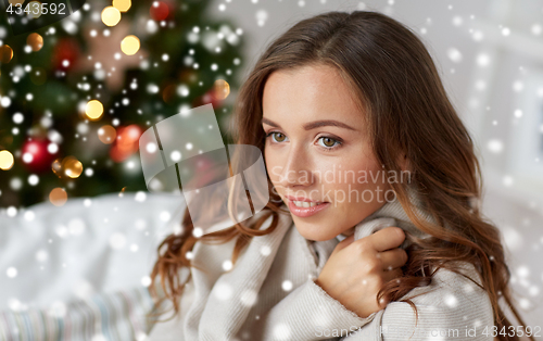 Image of happy young woman with plaid at home for christmas