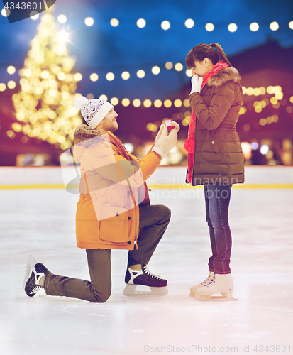 Image of couple with engagement ring at xmas skating rink