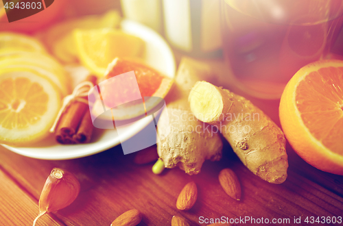 Image of ginger, citrus fruits, tea or honey on wood