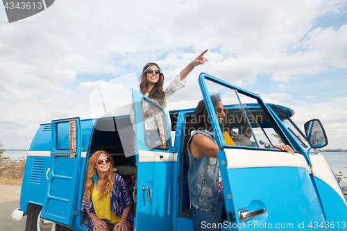 Image of smiling happy young hippie friends at minivan car