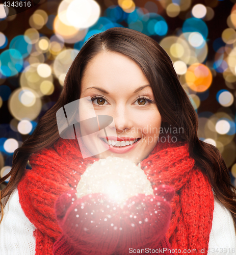 Image of woman in scarf and mittens with christmas ball