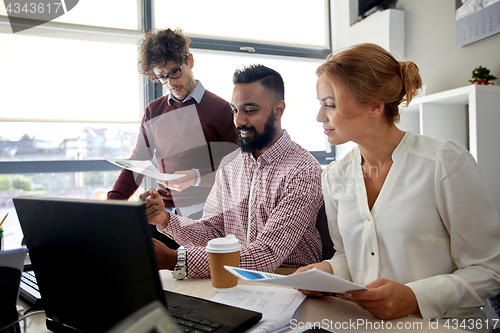 Image of business team with laptop and coffee in office