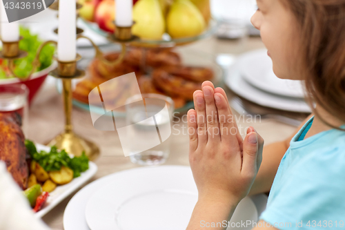 Image of close up of girl having dinner and praying at home
