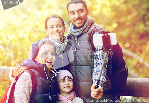 Image of happy family with smartphone selfie stick in woods