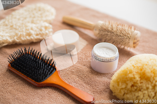 Image of hair brush, cream, sponge, soap bar and bath towel