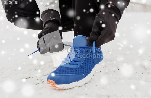 Image of close up of man tying shoe lace in winter outdoors