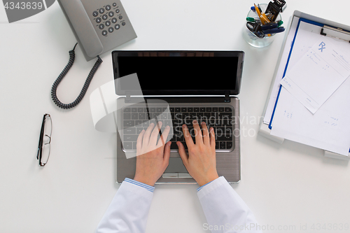 Image of woman doctor hands typing on laptop at clinic